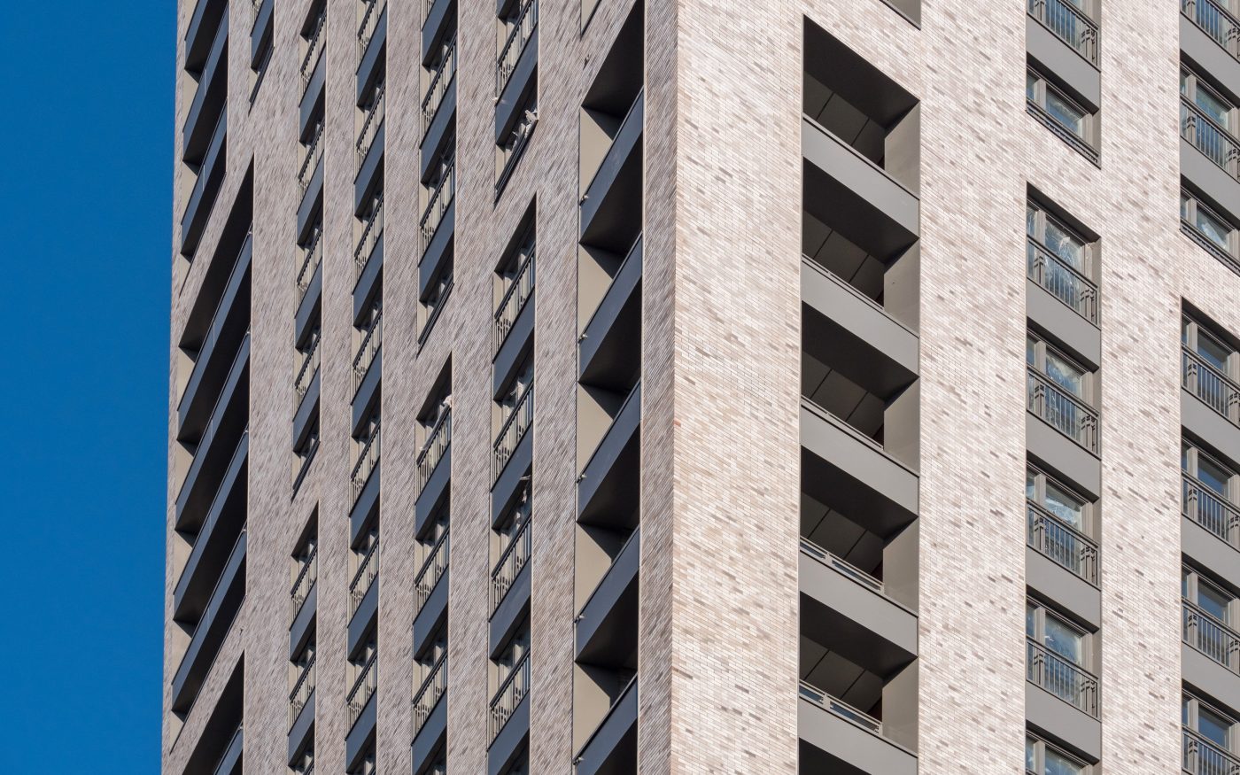 Windows and balconies on modern apartment building with grey Corium facade