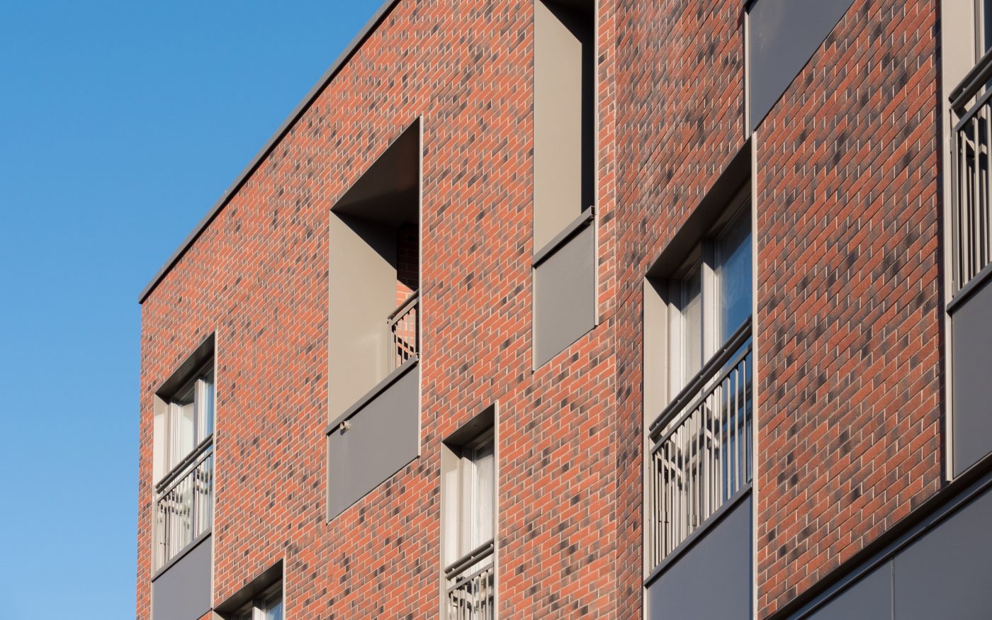 Close up of the red brick facade on new multi-storey residential block