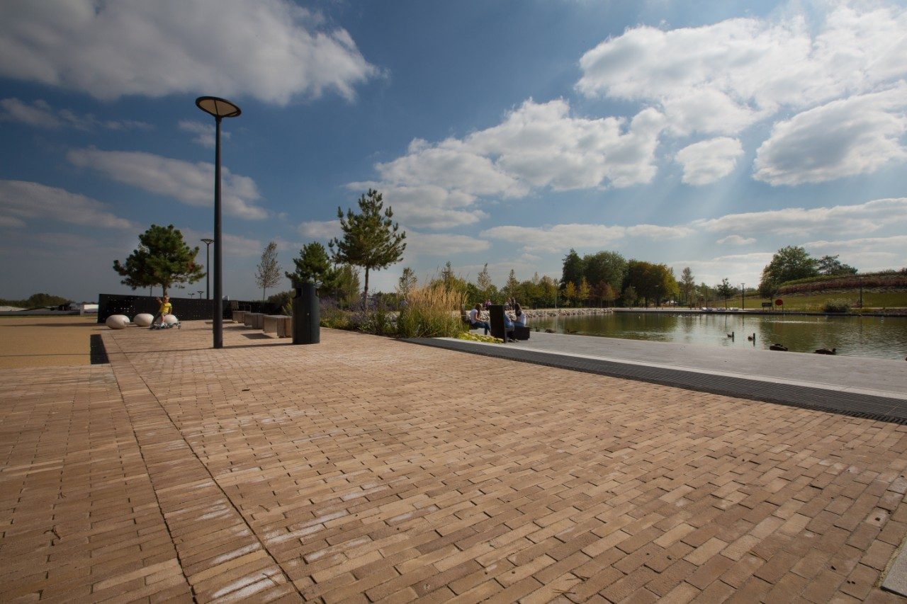 Paved landscaping outside with benches, buildings in the distance