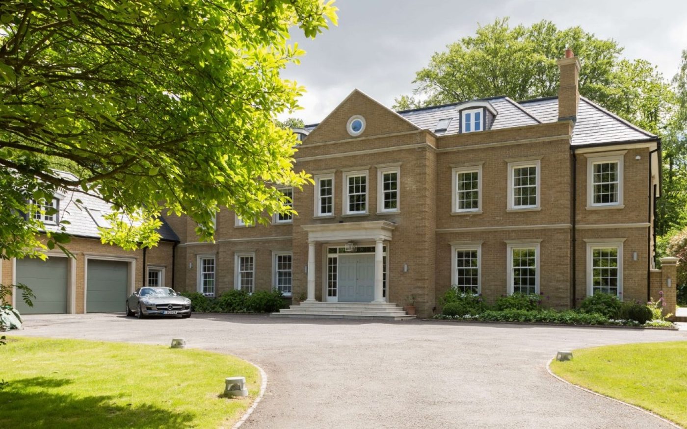 Big grand home with drive way leading up to pillars and large front entrance
