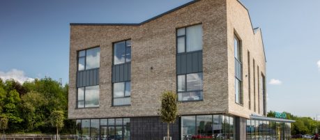 Tall multi storey building with large windows and blue sky