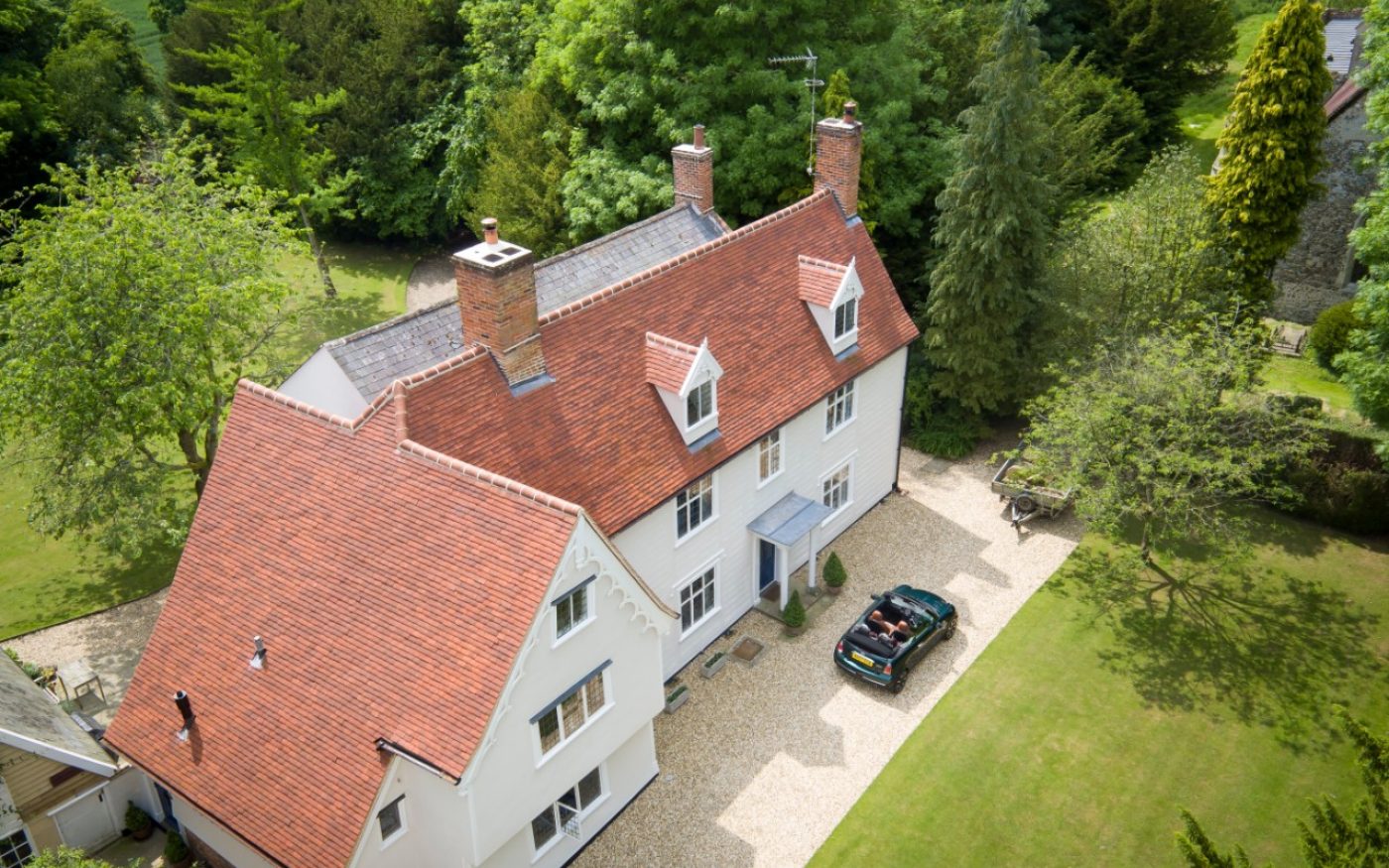 Car parked in driveway of large old house with renovated roof