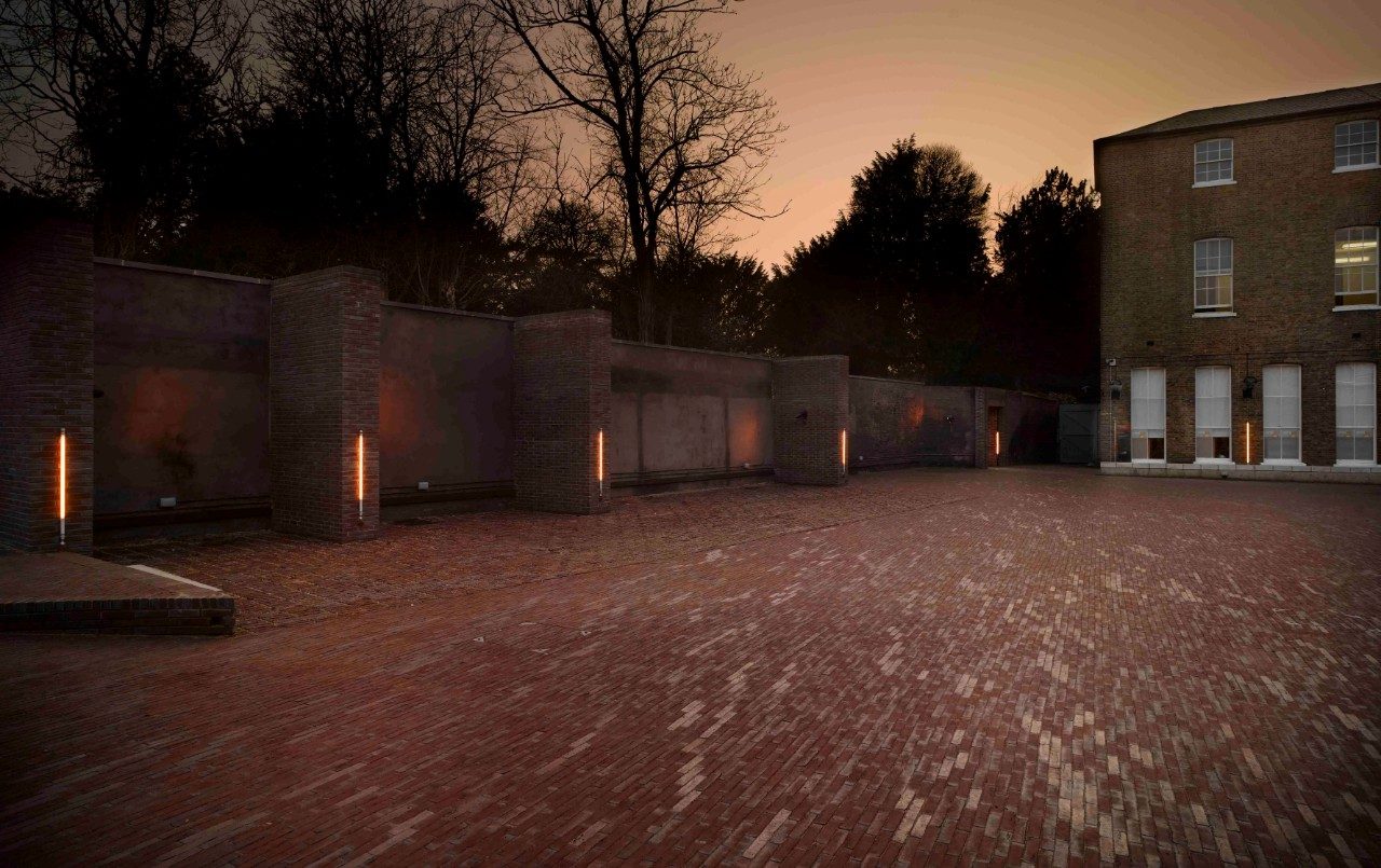 Outdoors clay paved area outside university building at dusk