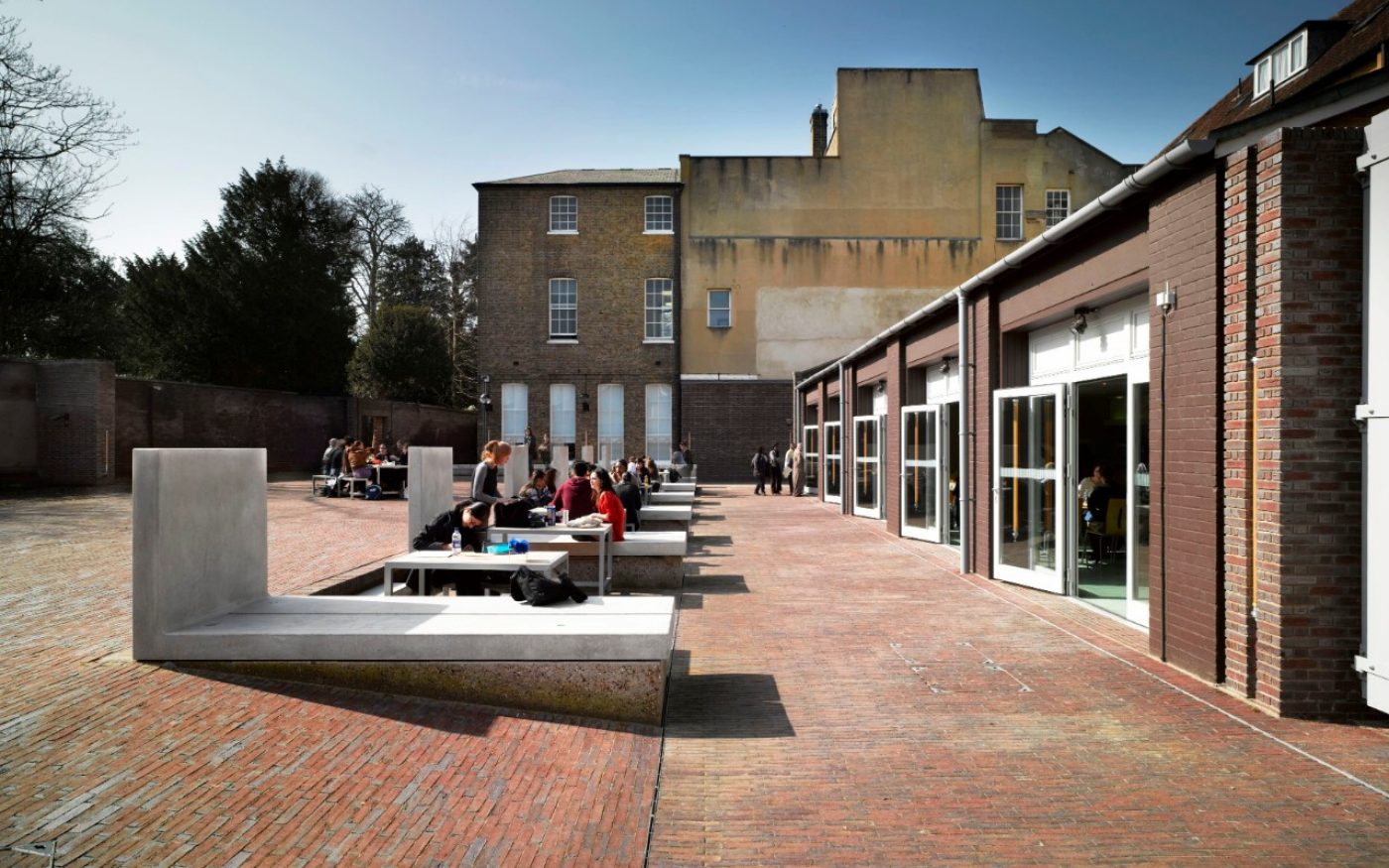 Paved open space at the University of Roehampton with student sat on benches