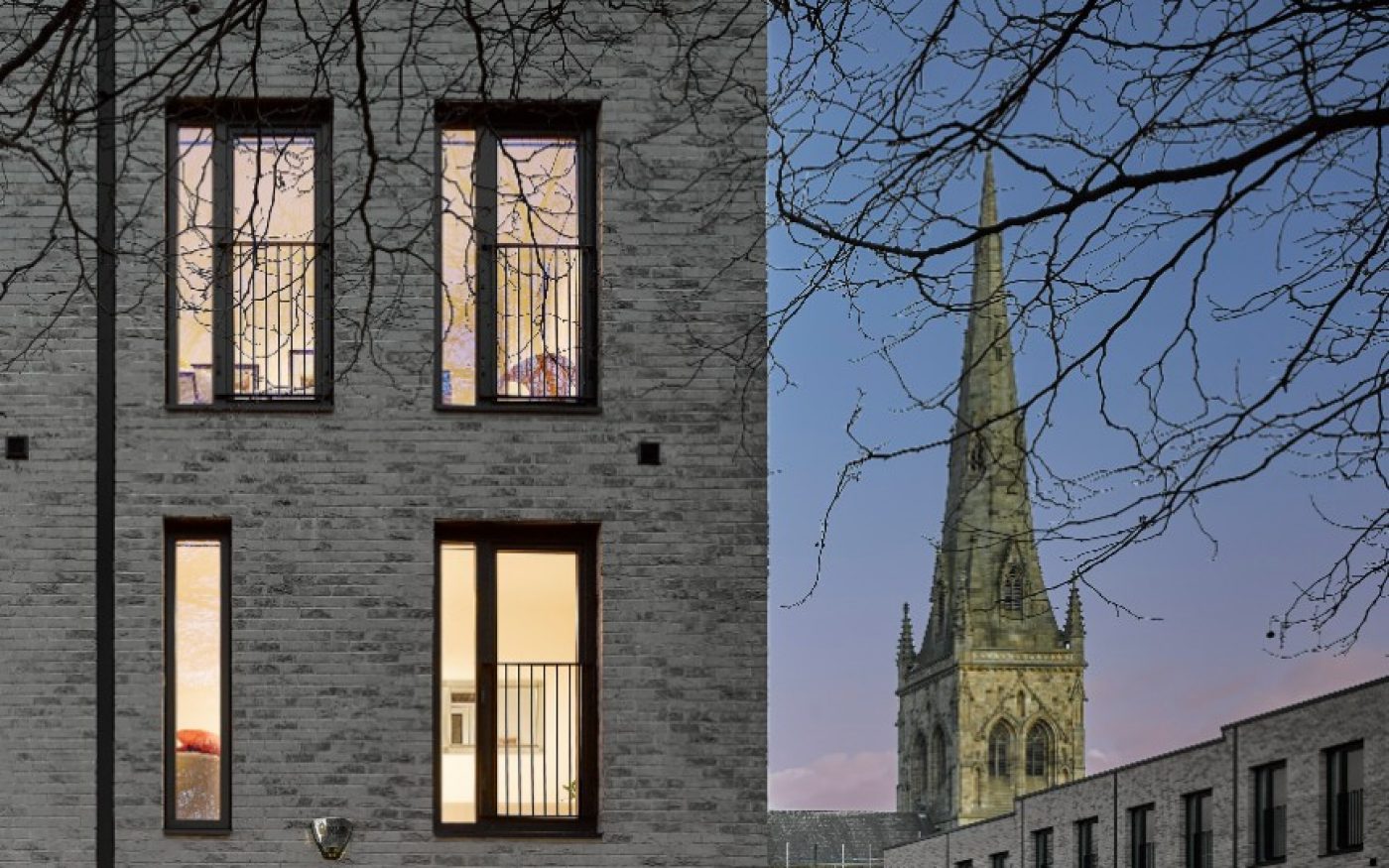 Modern grey brick wall with traditional church spire in the background