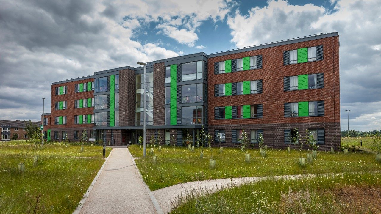 University building with red brick surrounded green lawns