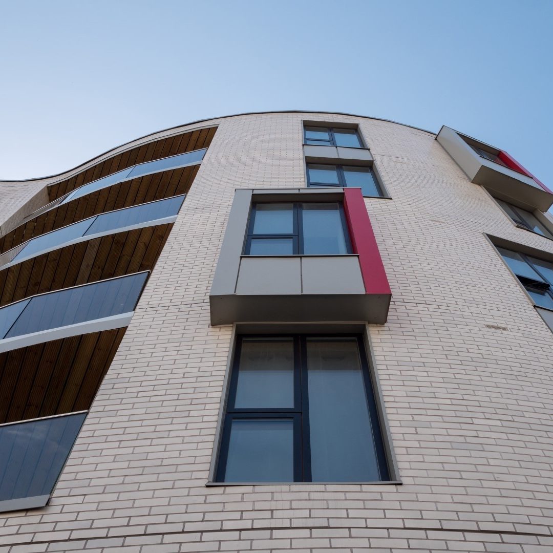 Looking up at a grey brick multi storey building