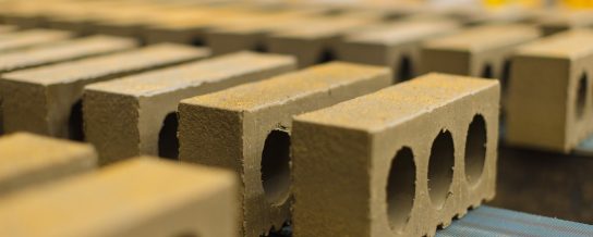 Man picking up bricks at a construction site