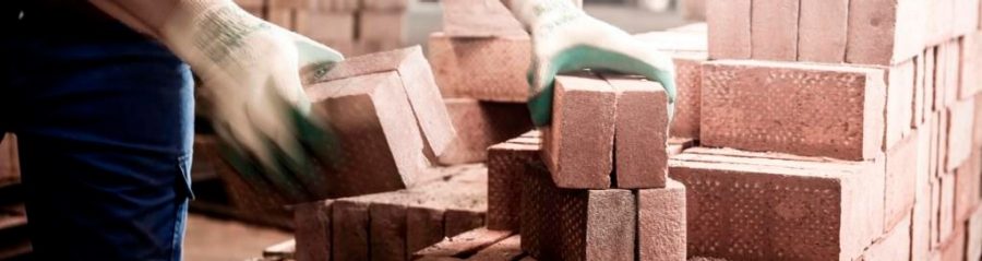 Man moving clay pavers in factory