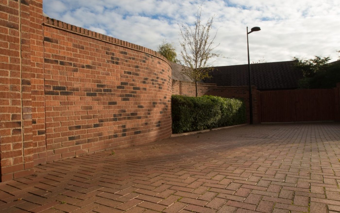 Clay pavers used to landscape a drive way leading up to a residence