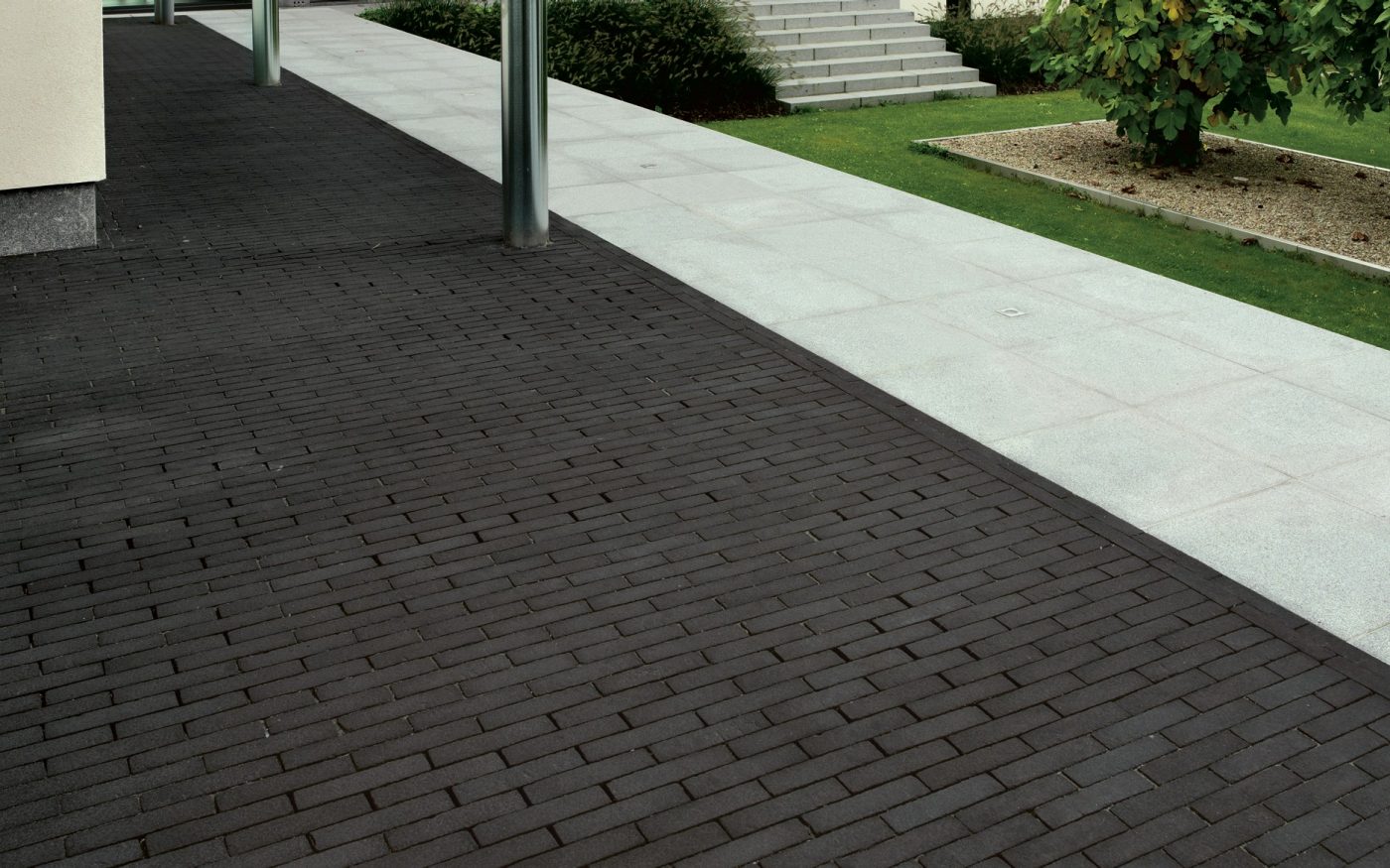 Dark grey pavers contrasting next to white paved path