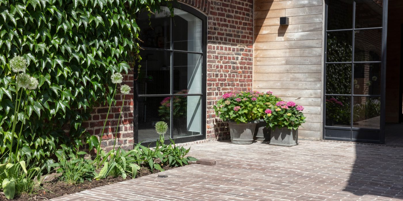 Rustic paved courtyard with plant pots and flowers