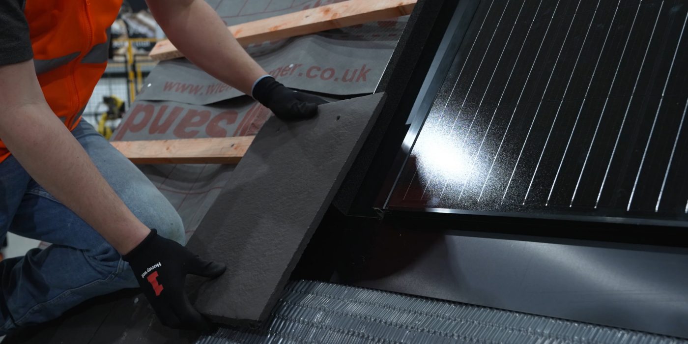 Installer placing a roof tile onto a roof